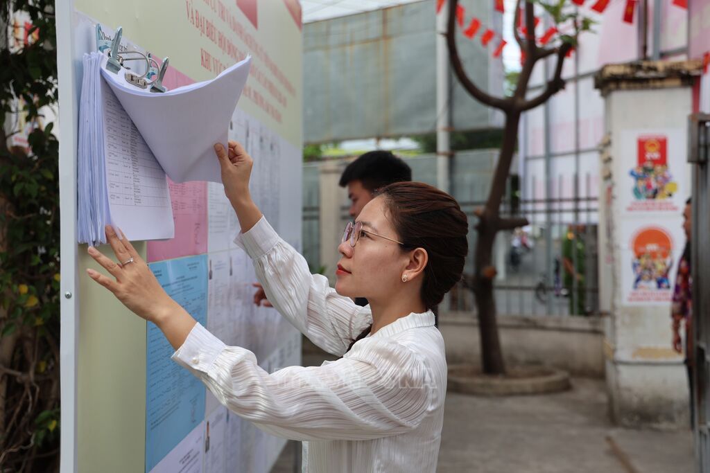 Người dân Nha Trang theo dõi thông tin tuyên truyền về bầu cử được niêm yết tại khu dân cư.&nbsp;